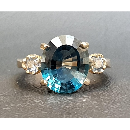 86 - BLUE TOPAZ AND SAPPHIRE THREE STONE RING
the central oval cut topaz approximately 4.8cts, flanked by... 