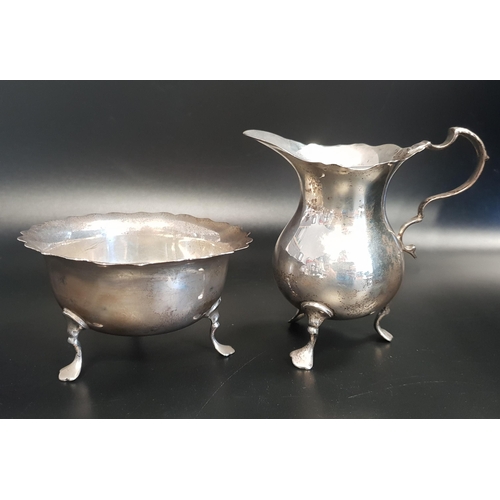 129 - GEORGE V SILVER CREAM JUG
of baluster form with a wavy rim and raised on three feet, together with a... 