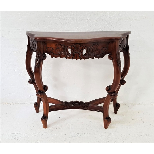 414 - INDONESIAN TEAK SIDE TABLE
with a shaped top above a carved frieze, standing on carved and shaped su... 