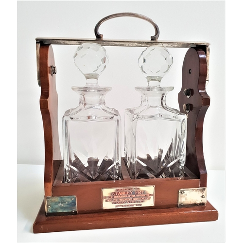 204 - MAHOGANY TANTALUS
with silver plated mounts and two decanters with stoppers, with a presentation pla... 