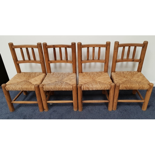 401 - SET OF FOUR RUSTIC PINE DINING CHAIRS
with bow shaped backs with turned columns above woven rush sea... 