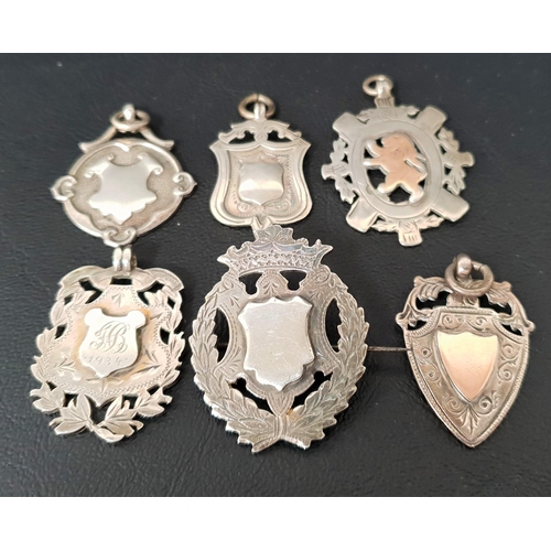 122 - SIX VICTORIAN AND LATER SILVER MEDAL FOBS
including two with gold detail, one with brooch attachment... 