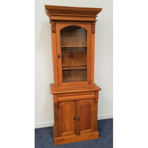 399 - LARGE LIGHT TEAK SIDE CABINET
with a moulded cornice above an arched glazed door opening to reveal a... 