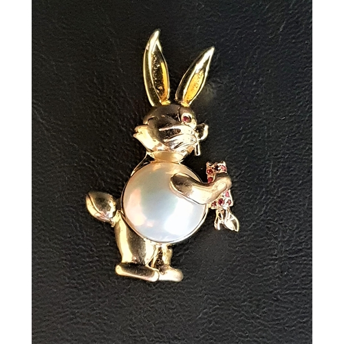 10 - MABE PEARL SET RABBIT BROOCH
in fourteen carat gold with ruby eye and ruby set carrot, 4.2cm high an... 
