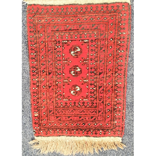 499 - AFGHAN PRAYER MAT 
with a red ground and three central medallions, encased by a border, fringed, 88c... 