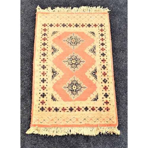 503 - PAKISTAN BOKHARA RUG
with a pink ground with lozenge motifs, encased by a geometric border, fringed,... 