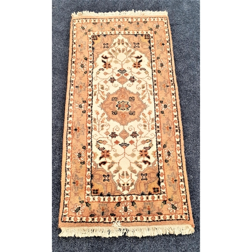 507 - PERSIAN RUG
with a cream and tan ground encased by a floral border, fringed, 145cm x 69cm