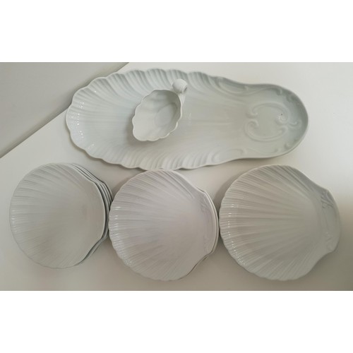 203 - PORCELAIN FISH PLATES
in white and comprising a fish serving plate, shell shaped sauce boat and elev... 