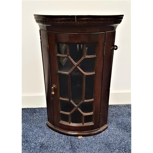 519 - 19th CENTURY MAHOGANY BOW FRONT CORNER CUPBOARD
with a moulded dentil pediment above an astragal gla... 