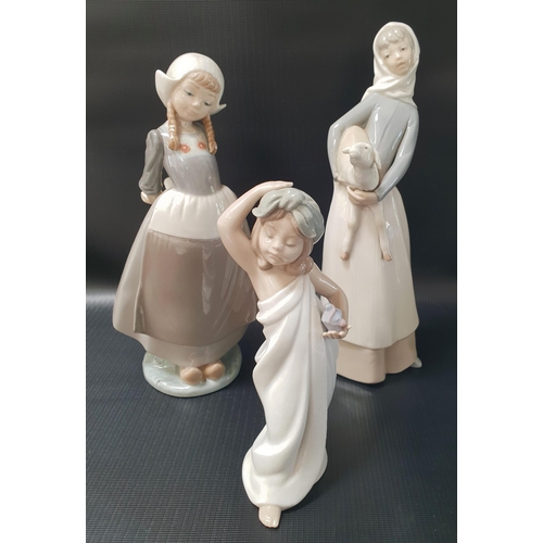 259 - THREE LLADRO FIGURINES
depicting a young girl wrapped in a towel, 18.5cm high, a Dutch girl in clogs... 