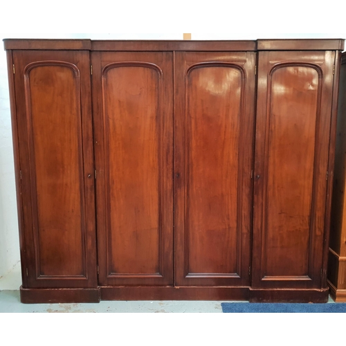 591 - VICTORIAN MAHOGANY INVERTED BREAKFRONT WARDROBE
with four arched panelled doors opening to reveal ce... 