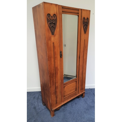 600 - ART NOUVEAU OAK WARDROBE
with a central bevelled mirror door flanked by carved stylised panels, stan... 