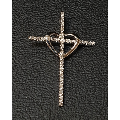 142 - DIAMOND SET CROSS PENDANT
with central heart detail, in unmarked white gold, 3.2cm high