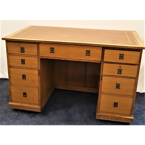 587 - LIGHT OAK KNEEHOLE DESK
with an inset top above an arrangement of nine drawers with recessed brass h... 