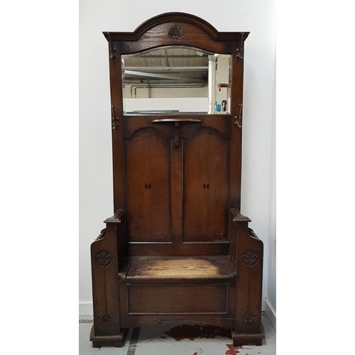 512 - OAK HALL STAND
with an arched top and carved shell motif above a shaped bevelled mirror with a centr... 