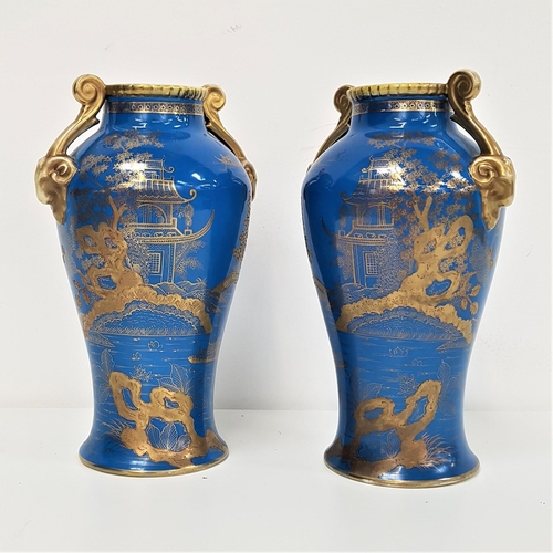 240 - PAIR OF NORITAKE BALUSTER VASES
with a cobalt blue ground and gilt scroll handles, decorated with pa... 