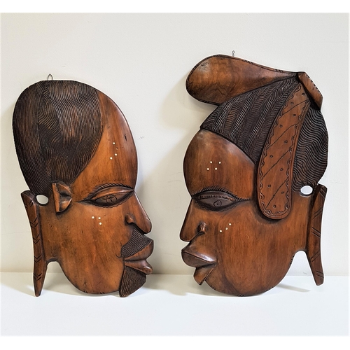 280 - AFRICAN CARVED TEAK WALL PLAQUE
of a male and female head in profile, 47cm and 45cm high (2)