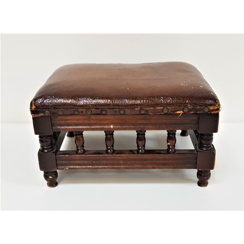 597 - EDWARDIAN MAHOGANY FOOTSTOOL
with a rectangular padded top above galleried turned columns, standing ... 