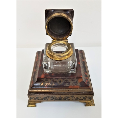 274 - LATE 19th CENTURY TORTOISESHELL AND BRASS BOULLE INK STAND
with a heavy cut glass inkwell having a h... 