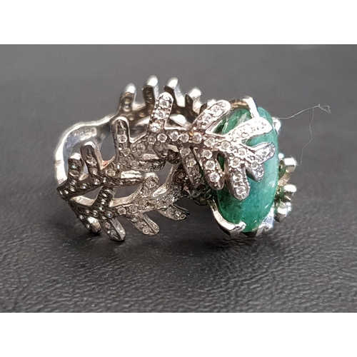 92 - UNUSUAL EMERALD AND DIAMOND DRESS RING
the central oval cut emerald within a diamond set fern effect... 