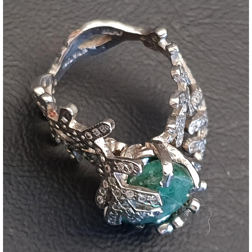 92 - UNUSUAL EMERALD AND DIAMOND DRESS RING
the central oval cut emerald within a diamond set fern effect... 