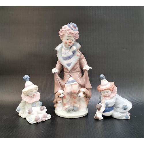 262 - THREE LLADRO CLOWN FIGURINES
comprising a larger example with dogs to either side, 25.2cm high; toge... 