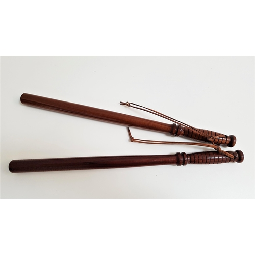 300 - TWO MAHOGANY TRUNCHEONS
with turned ribbed handles and leather wrist straps, each 55.5cm long (2)