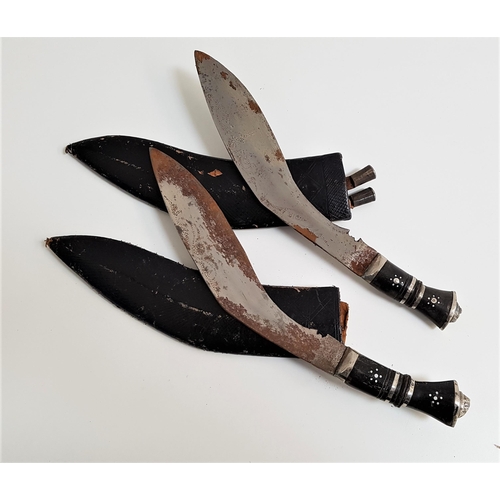 307 - TWO KUKRI KNIVES
each with a curved etched blade, 29.5cm long, with an ebony handle and lion mask po... 