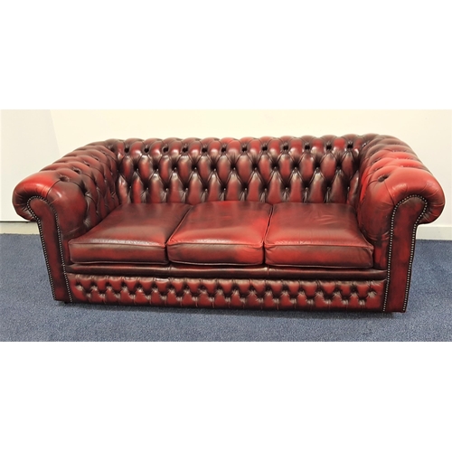 532 - CHESTERFIELD SOFA
in ox blood red leather with a button back and scroll arms with decorative stud de... 