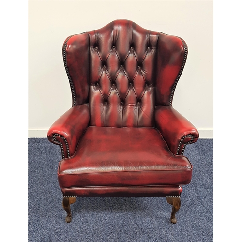 535 - CHESTERFIELD SHAPED WINGBACK ARMCHAIR
in ox blood red leather with a button back and scroll arms wit... 