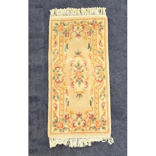 607 - CHINESE WASH RUG
with a mushroom ground and floral motifs, 156cm x 78cm