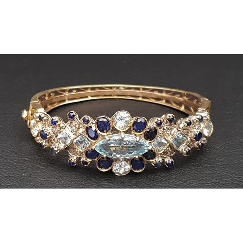 72 - BLUE TOPAZ, SAPPHIRE AND DIAMOND SET BANGLE
in silver gilt with pierced detail to the reverse of the... 