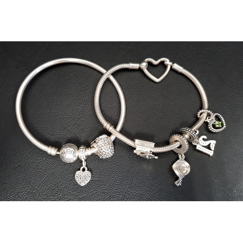 67 - TWO PANDORA CHARM BRACELETS
comprising a Moments Heart Closure Snake Chain Bracelet with four charms... 