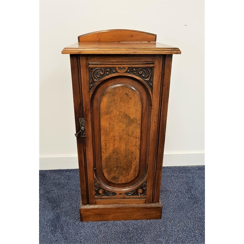 519 - EDWARDIAN WALNUT BEDSIDE POT CUPBOARD
with a shaped arched raised back above a plain top with a carv... 