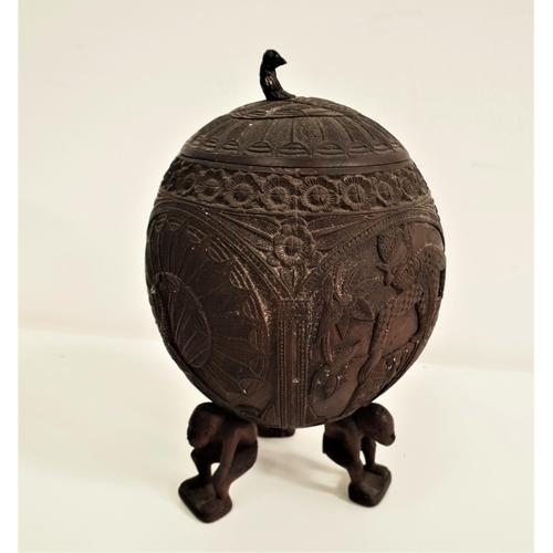 353 - CARVED COCONUT CUP AND COVER
with a peacock finial, the body decorated with a peacock and figures, s... 