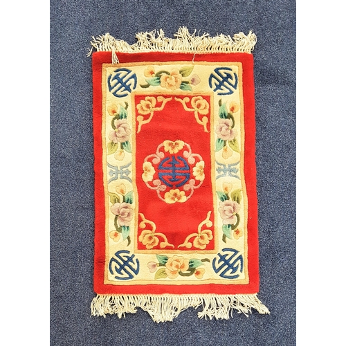 579 - CHINESE RECTANGULAR WASH RUG
with a red ground and cream border, fringed, 95cm x 63cm excluding frin... 