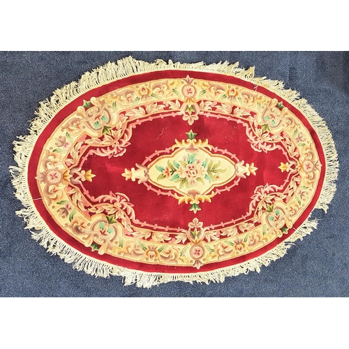 580 - CHINESE OVAL WASH RUG
with a burgundy ground and centered with flowers and encased with a floral bor... 