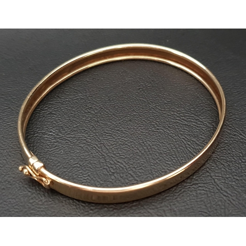 2 - NINE CARAT GOLD BANGLE 
with safety clasp, approximately 6.3 grams