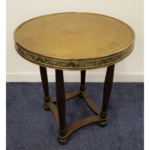 562 - EAST ASIAN OCCASIONAL TABLE
with a circular brass embossed top, standing on turned supports with bun... 