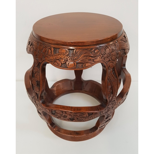 635 - CHINESE TEAK STOOL/STAND
of typical barrel form with a circular top above carved dragons, 46cm high