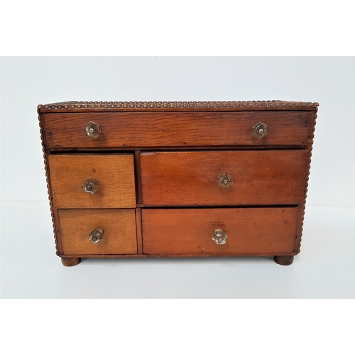 333 - PINE TABLE TOP CABINET
with bobbin moulding to the rectangular top above an arrangement of five draw... 