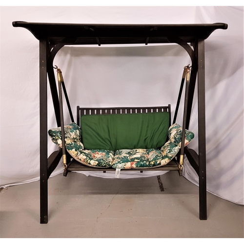 542 - STAINED TEAK GARDEN SWING BENCH
with a slatted canopy above a two seat slatted bench on A frame supp... 