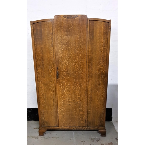 554 - 1950s OAK WARDROBE
with carved detail and a central door opening to reveal a mirror, two hanging rai... 