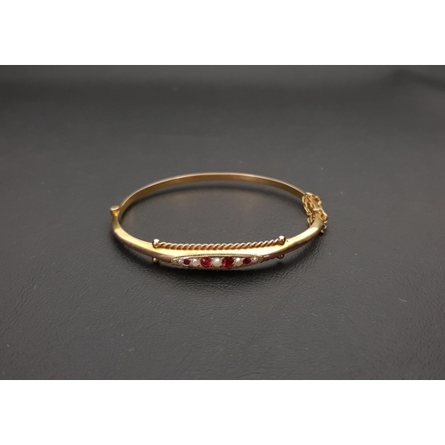 37 - EDWARD VII RED GEM AND SEED PEARL NINE CARAT GOLD BANGLE
the hinged bangle with rope twist detail ab... 