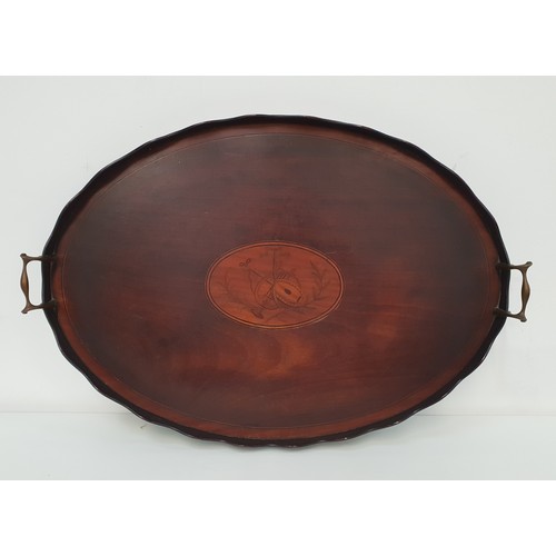 357 - MAHOGANY AND INLAID OVAL TRAY
with a scalloped border and shaped brass carrying handles, 65.5cm wide