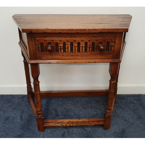 614 - OAK CREDANCE STYLE TABLE
with a shaped top above a carved drawer, standing on turned supports united... 