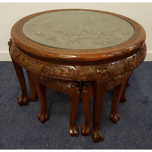 636 - CHINESE TEAK OCCASIONAL NEST OF TABLES
with a circular carved top depicting warriors on horses under... 