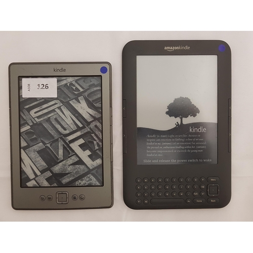 126 - TWO AMAZON KINDLE E-READERS
comprising Kindle No Touch Silver, serial number B00E 1501 1415 3K94; an... 