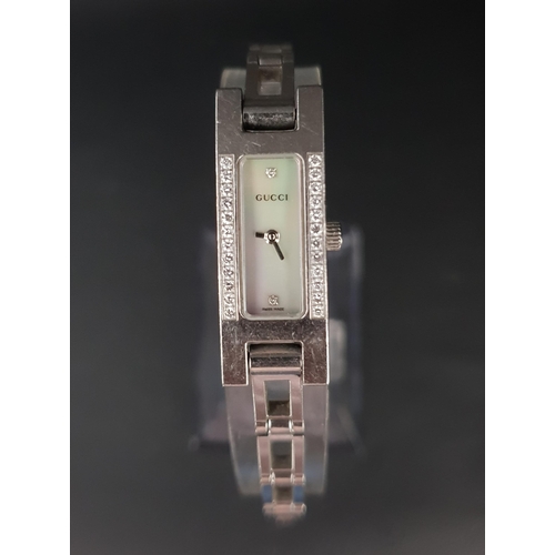48 - LADIES GUCCI WATCH 
with diamonds flanking the rectangular mother-of-pearl face, with further diamon... 