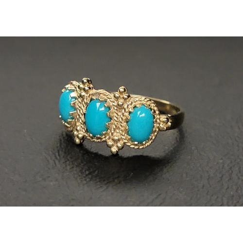 142 - TURQUOISE THREE STONE RING 
with three oval cabochon turquoise sections in a decorative setting, on ... 